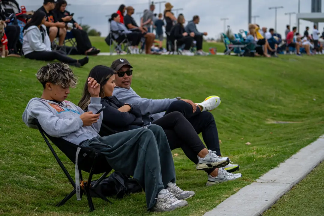 Family watching a youth soccer game from the sideline